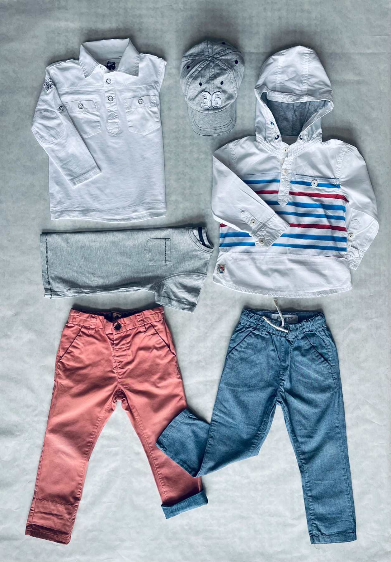 Sportosan elegáns 6 db-os átmeneti/nyári NEXT ruhaszett 1,5-2 éveseknek. A csomagban 2 vékony nadrágot, 2 hosszú ujjút, 1 rövid ujjú pólót és egy baseball sapkát találsz.