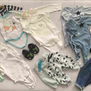 20 db-os kék-fehér színösszeállítású mini kapszulagardrób 0-3 hós babáknak: 2 cuki csillagos rugi, 3 trikós body, 1 rövid ujjú body, 3 hosszú ujjú body, 2 vékony nadrág, 2 bélelt melegítő nadrág, 4 pár zokni, 1 bőrmamusz, 1 vagány terepes textilszandi, és egy vékony sapi.